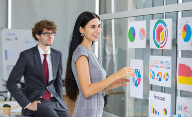 Elegant woman entrepreneur smile and happy for presentation report of successful business operation from caucasian corporate manager and enjoy visiting marketing analysis exhibition in office