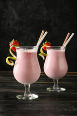 Glasses of strawberry Pina Colada cocktail on dark wooden table