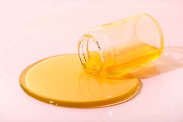 Overturned jar with honey on color background