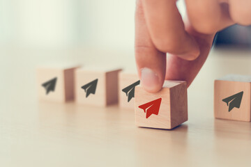 Business concept for new ideas creativity and innovative solution. Business opportunity concept.  Businessman chooses red paper plane symbol on wooden cube standing with others on white background.