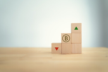 Bitcoin crypto currency; financial investment concept. Positive profit and negative loss concept.  Bitcoin & arrow symbolizing on wooden cubes that the value going up or down.  White background banner