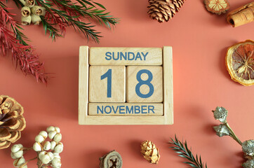 November 18, Cover design with calendar cube, pine cones and dried fruit in the natural concept.