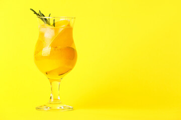 Glass of cold melon cocktail on yellow background