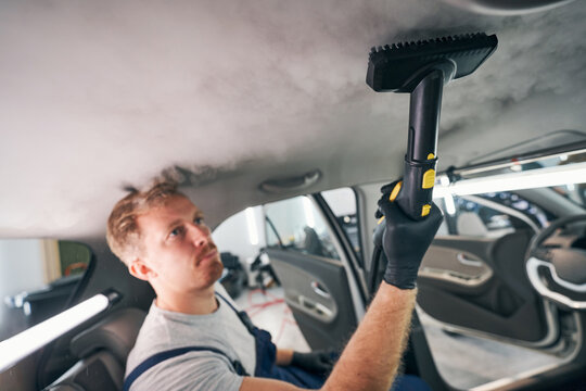 Worker conducts steam sterilization and dry cleaning of car interior