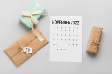Calendar page of November 2022 and gifts on grey background. Black Friday