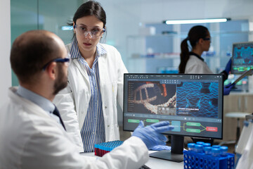 Scientist team discussing coronavirus discovery analyzing biomedical expertise developing virus vaccine during medical experiment. Biologists working in hospital laboratory. Treatment investigation