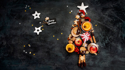 Christmas tree made of food on dark background.