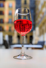 Glass of Spanish rose or rosado with a blurred building background in a restaurant on a square in the old town or Casco Viejo of Pamplona, Spain