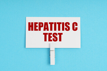 On a blue background, there are pills and a business card with the inscription - Hepatitis C test