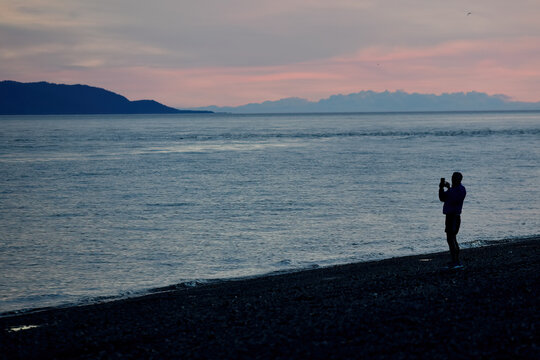 A photographer captures images of Kachemak Bay at sunset in Homer, Alaska.