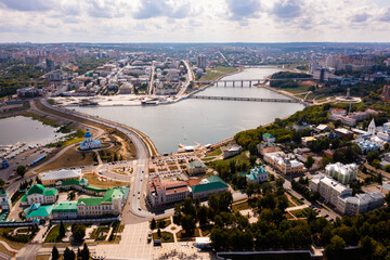Fototapeta premium Scenic view from drone on sunny summer day of Cheboksary cityscape on banks of Volga river overlooking Holy Trinity Monastery and Assumption Church, Chuvashia, Russia