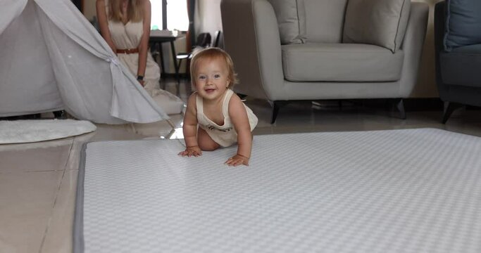 Authentic close up Cute Caucasian Baby Girl 1 year old Playing on floor in living room at home. Slow Motion.
