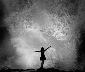 silhouette of girl in front of a large ocean wave