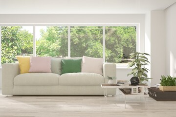 White living room with sofa and summer landscape in window. Scandinavian interior design. 3D illustration