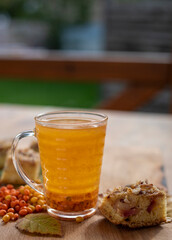 good morning heart with sea buckthorn and blackberry leaves on a wooden surface