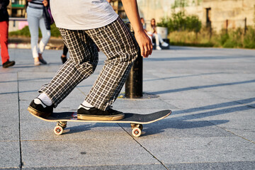 Skateboarder ride on skateboard at city street. Scater practice skate board tricks at skatepark. Teenager extreme sport