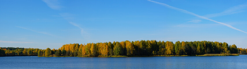 Fototapeta premium Autumn landscape. Panorama of the lake shore, clear sky and colorful forest. September or october in Russia.