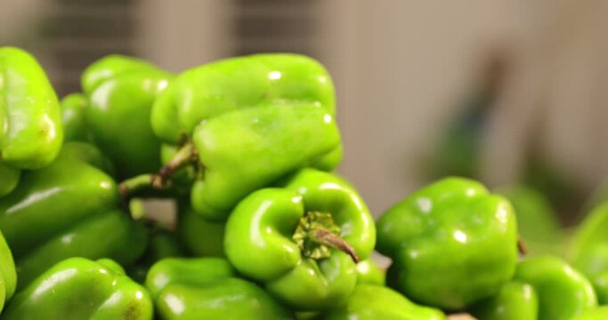 green bell peppers or capsicum  in a basket on table
