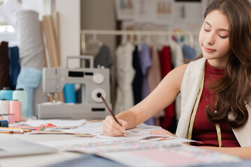 Young fashion designer woman drawing sketches pattern clothes. dressmaker working in workshop studio desk. SME small business owner self-employed.