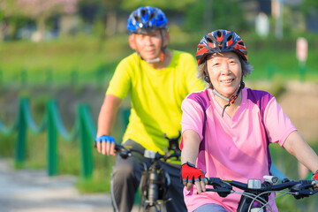 Happy  senior couple exercising with bicycles in the park