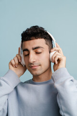 Young middle eastern man listening music with headphones