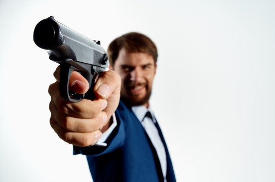 The man in a suit with a pistol in hand crime detective killer light background