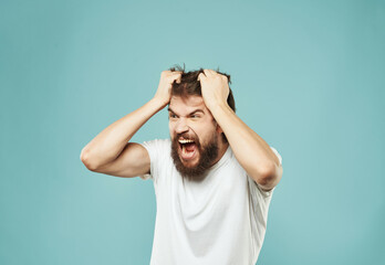 emotional man in a white t-shirt irritated facial expression blue background