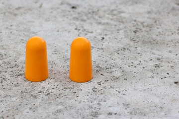 Two orange soft foam ear plugs with copy space