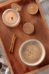 Hygge. Breakfast tray with coffee and scented candles, overheaed flat lay shot on a warm blanket