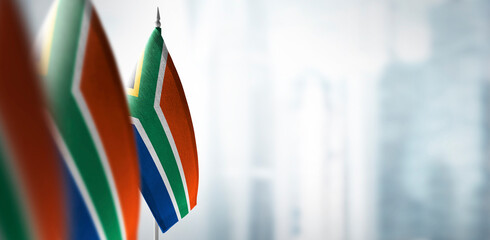 Small flags of South Africa on a blurry background of the city
