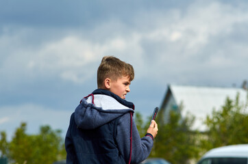A boy with smartphone watching the competition