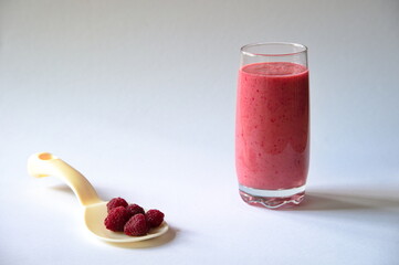 Fresh raspberries and smoothie on white background