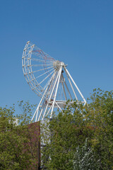 Ferris wheel construction on blue sky.