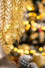 Golden garland in focus. Christmas tree with lights out of focus. Festive season decorations and elements concept