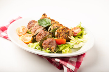 Traditional Sicilian meat rolls on white plate served with salad close up