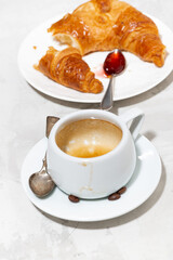 empty cup of coffee, fresh croissant with strawberry jam