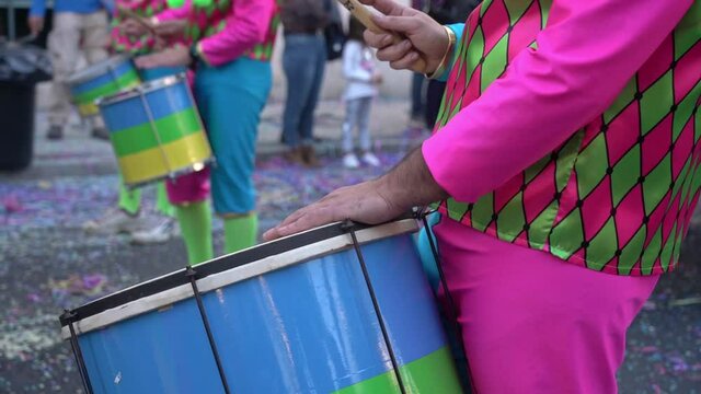 A group of drummers playing rhythmic music during the parade at the carnival. Dressed in colorful traditional costumes.
