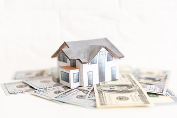 mortgage, investment, real estate and property concept - close up of home model, dollar money