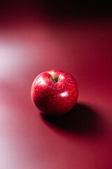 Red ripe apple on a red background.