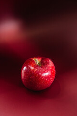 Red ripe apple on a red background.