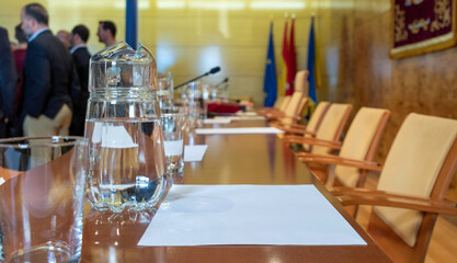 meeting room prepared for an event. Water pitcher and drinking glasses in the foreground