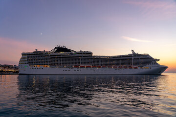 huge cruiser ship at sunset with lights