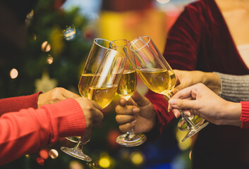 Beverage glasses clinking moment by cheerful woman friends on sweater as enjoy celebrating happy relationship at delightful event of Chirstmas night party