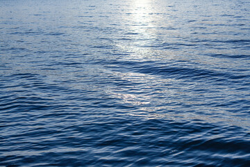 Blue sea waves surface, ripple water texture, beautiful quiet ocean background, abstract aqua pattern backdrop, sunset reflection, sun light glow, dark night shiny moonlight at lake, river, top view