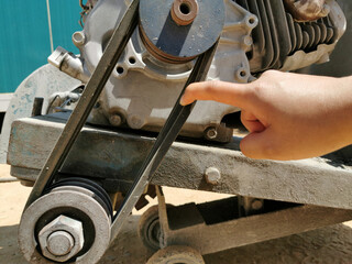 index finger is touching machine belt, hand with concrete cutter, checking is machine, testing of mechanical and thermal sensors and devices