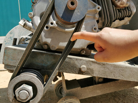 index finger is touching machine belt, hand with concrete cutter, checking is machine, testing of mechanical and thermal sensors and devices