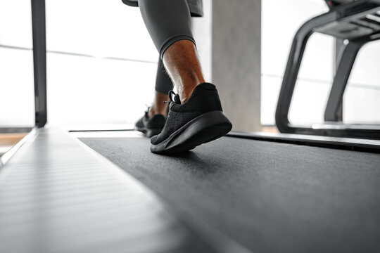 Close up of male legs running in a gym on a treadmill