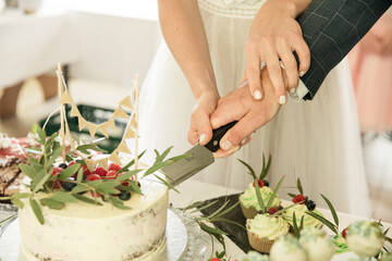 Brautpaar schneidet Hochzeitstorte an 