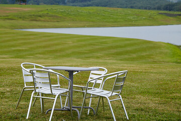 Close-up of outdoor leisure tables and chairs by the lake in the outdoor grass