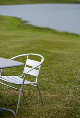 Close-up of outdoor leisure tables and chairs by the lake in the outdoor grass